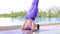 Asian woman playing yoga beside swimming pool