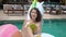 Asian woman in pool drinking a coconut fruit