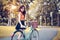 Asian woman portrait in public park with bicycle. People and Lifestyles concept. Relaxation and activity theme.