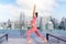 Asian woman pose yoga action on hotel rooftop with Bangkok city and swimming pool background