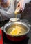 Asian woman pouring raw beaten egg