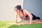 Asian woman practice push up on a training orange mat on green grass. wellness concept.