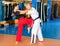 Asian woman practicing knee strike in sparring with man during self defence course