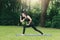 Asian woman practicing yoga in Prep Poses for Side Crane Pose for Parsva Bakasana on the mat in outdoor park