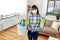 Asian woman in protective mask cleaning home