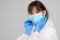 Asian woman puts on a protective mask and suit. Protected against flu, ebola, tuberculosis, virus.