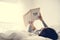 An Asian Woman Reading on a Bed in a Bright Minimal Room