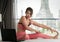 Asian woman relax with yoga on the hotel bed with Arun pagoda temple background between her travel trip