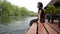 Asian woman relaxes by the river sitting on the edge of a wooden jetty