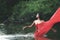 Asian woman relaxing and enjoying playing with water and splash at tropical exotic river with turquoise amazing color water in bea