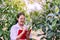 Asian woman researcher analysis and examining plant with study data in the garden