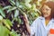 Asian woman researcher examining mango fruit and study information data in the garden