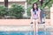 Asian Woman Resting at Poolside with Both Feet on The Water