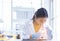 Asian woman scientist looking at microscope working test chemical in laboratory