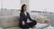 Asian woman seated cross-legged on couch do meditation practice