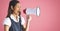 Asian woman shouting on megaphone against copy space on pink background