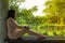 Asian woman sit on a bench against concrete pillar