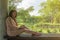 Asian woman sit on a bench against concrete pillar