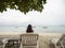 Asian woman sitting on beach chair looking away to sea view. Samed, Thailand.