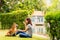 An Asian woman is sitting with a dog. A young woman is training a Shiba Inu in a park