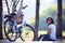 Asian woman sitting in the park with bicycle in morning use for helathy life and relaxing in holiday and vacation