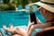 An Asian woman sitting at the swimming pool