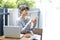 Asian woman sitting at a table and using smartphone at home. Typing text message, via cell phone, Social networking concept.