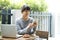 Asian woman sitting at a table and using smartphone at home. Typing text message, via cell phone, Social networking concept.