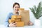 Asian woman small business owner smiling with many parcel of box to preparing order delivery to customer at home