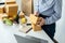 Asian woman small business owner standing to writing customer address on parcel of box and checking information