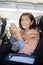 Asian woman with smart phone in hand sitting in air plane seat p