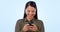 Asian woman, smartphone and texting with smile, laughing and on blue studio background. Social media, streaming and