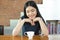 Asian Woman Smiling in front of coffee on the table