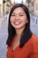 Asian woman smiling outdoors headshot