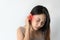 Asian woman with sore ear suffering from otitis with red accent. Stressed frowning young girl from strong ear pain feeling painful