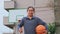 Asian woman in sportswear playing basketball at outdoor playground. Female basketball players practice outdoors on local courts.