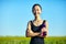 Asian woman in sportswear with water bottle standing in field