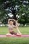 Asian woman sporty practicing yoga at public park outdoor, stretching her body. Healthy active lifestyle