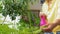 Asian woman spraying houseplant with water at home