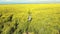 Asian woman standing in a field of canola flowers