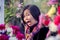 Asian woman standing in flower garden , making funny face