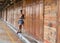 Asian woman standing next to wooden doors in empty floating mark