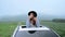 Asian woman standing out of car sunroof. Relaxing and freedom with spring time. Young tourist travel alone in Thailand on summer