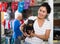 Asian woman standing in pet shop with her dog