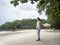 Asian woman standing under tree shadow looking the sea view. Samed, Thailand.