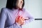 Asian woman with strong chest pain and hands touching her chest,Heart attack symptom