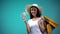 Asian woman in sun hat holding big sum of dollars and many shopping bags, loan