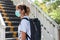 Asian woman with surgical face mask, standing near overpass bridge stairs