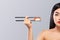 Asian woman with sushi eating sushi and rolls on a gray background. Copy space.