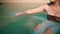 an Asian woman is swimming on the beach with blue sea water when she sits on the beach sand